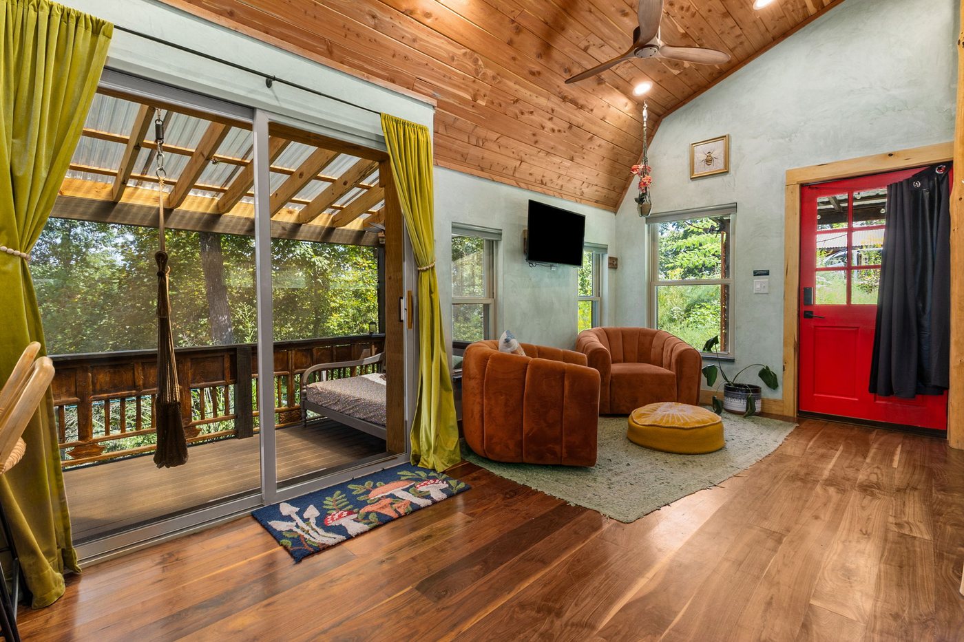 Blackbird living area with orange velvet chairs and TV