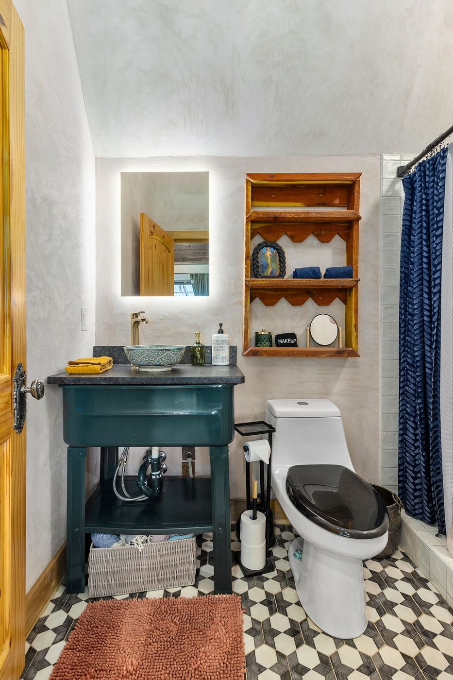 Blackbird bathroom with teal vanity and walk-in shower