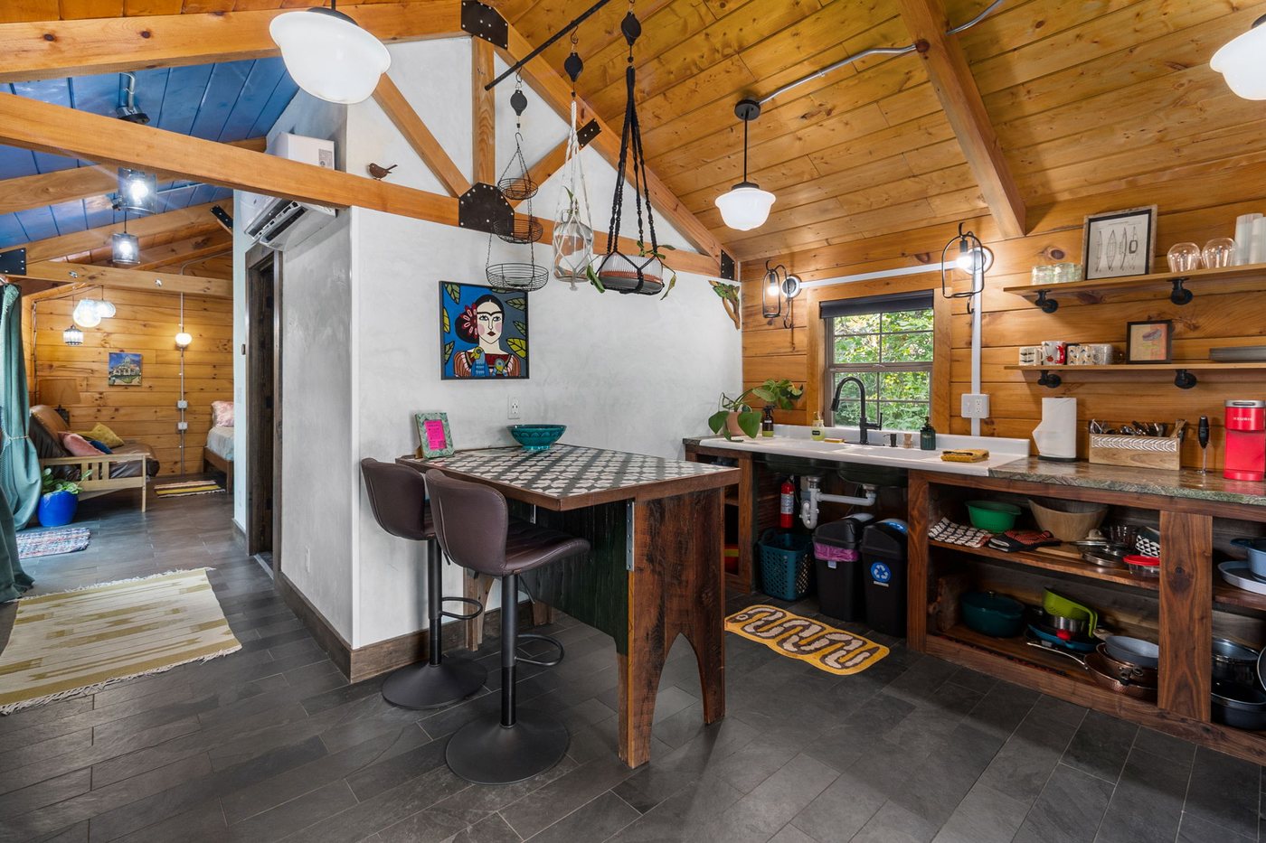 Chickadee open interior with dining table, kitchen and bed beyond