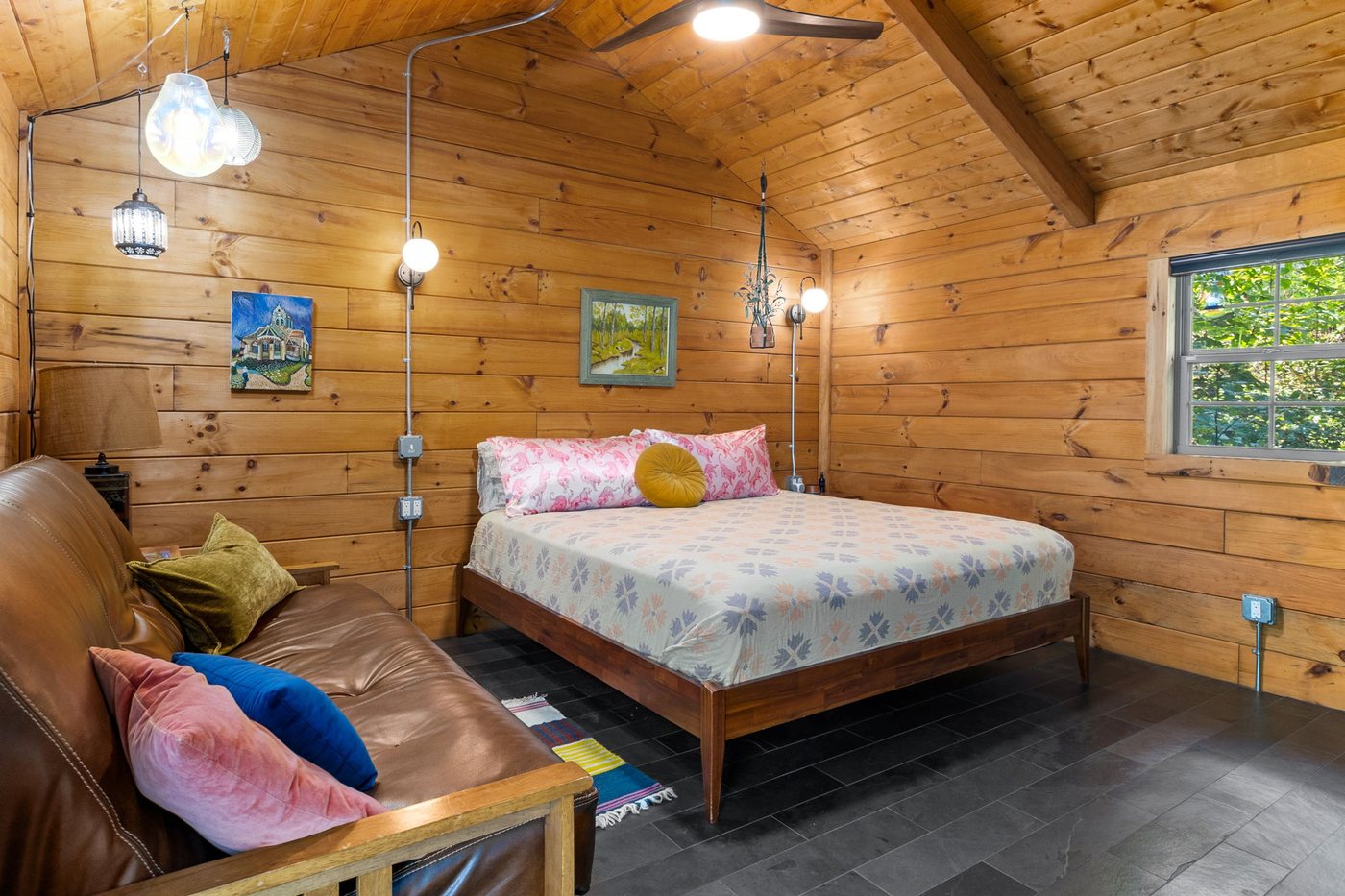 Chickadee king bed and leather futon under vaulted cedar ceilings
