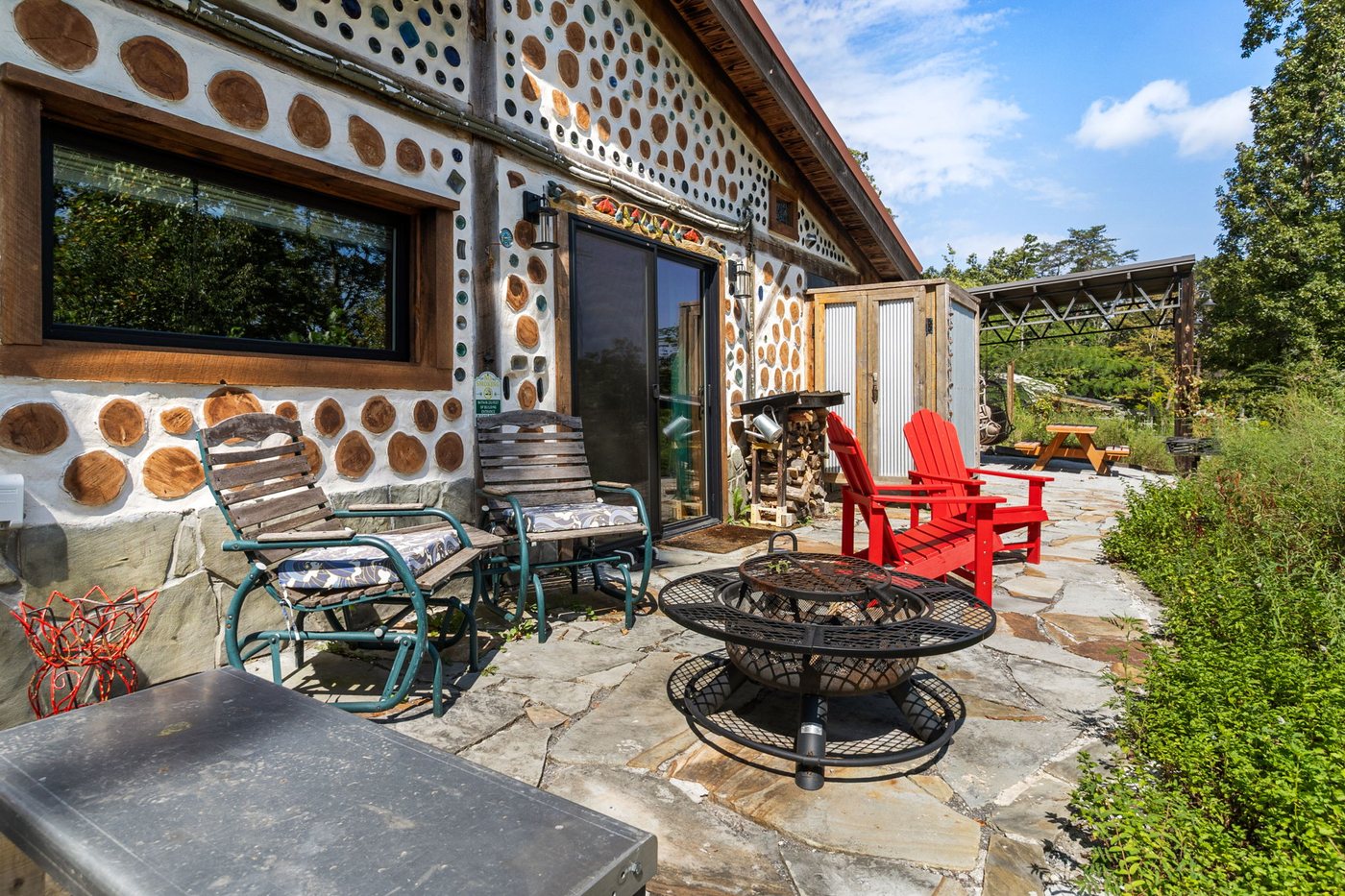 Goldfinch flagstone patio with red Adirondack chairs and firewood