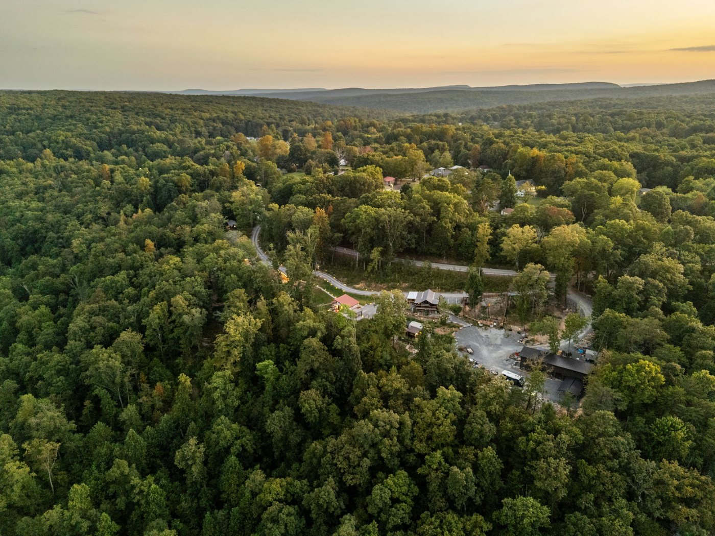 The retreat tucked into the forested ridge at golden hour