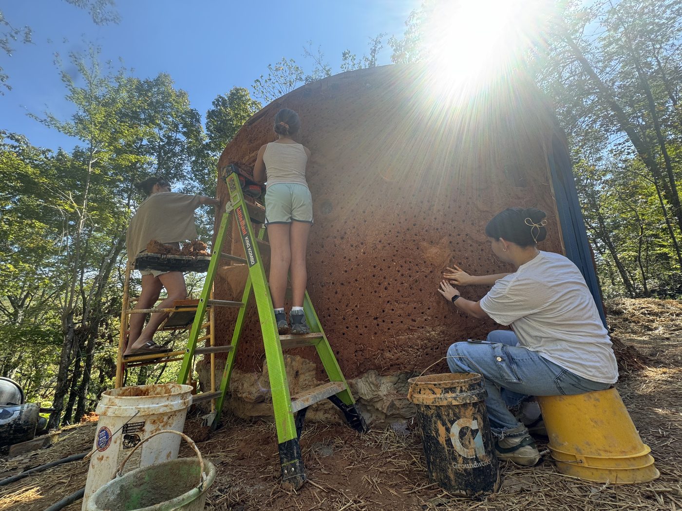 Plastering the exterior of the hut in the afternoon sun