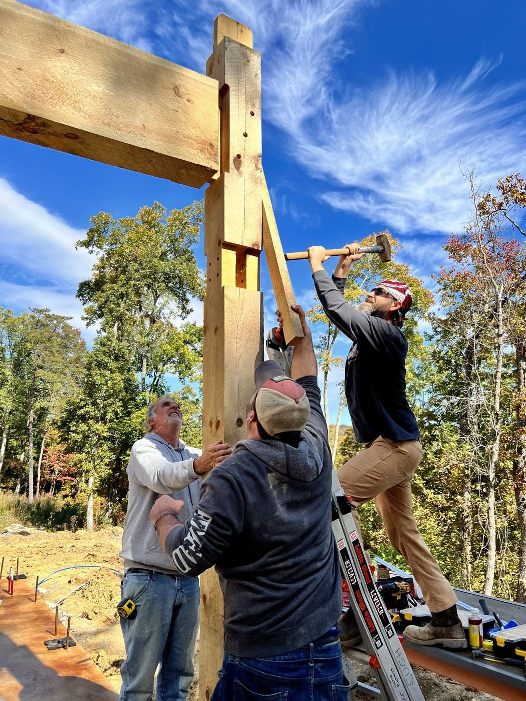 The family raising a timber frame by hand