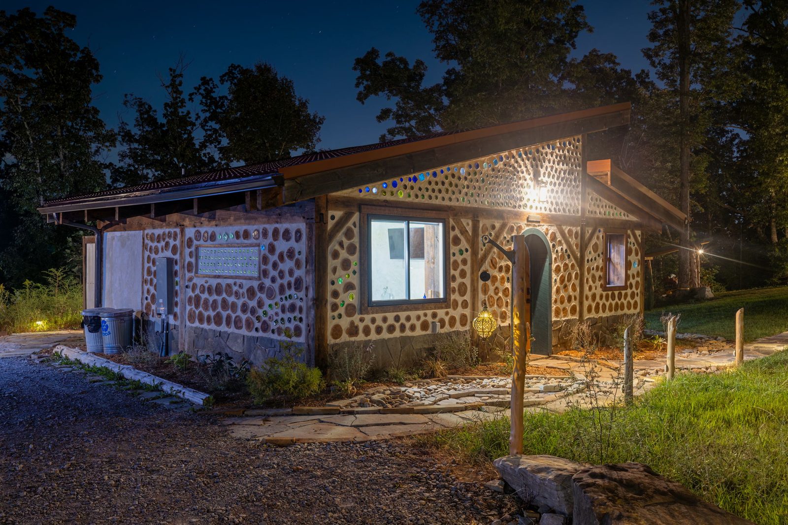 Goldfinch cordwood and bottle-glass walls lit up at night