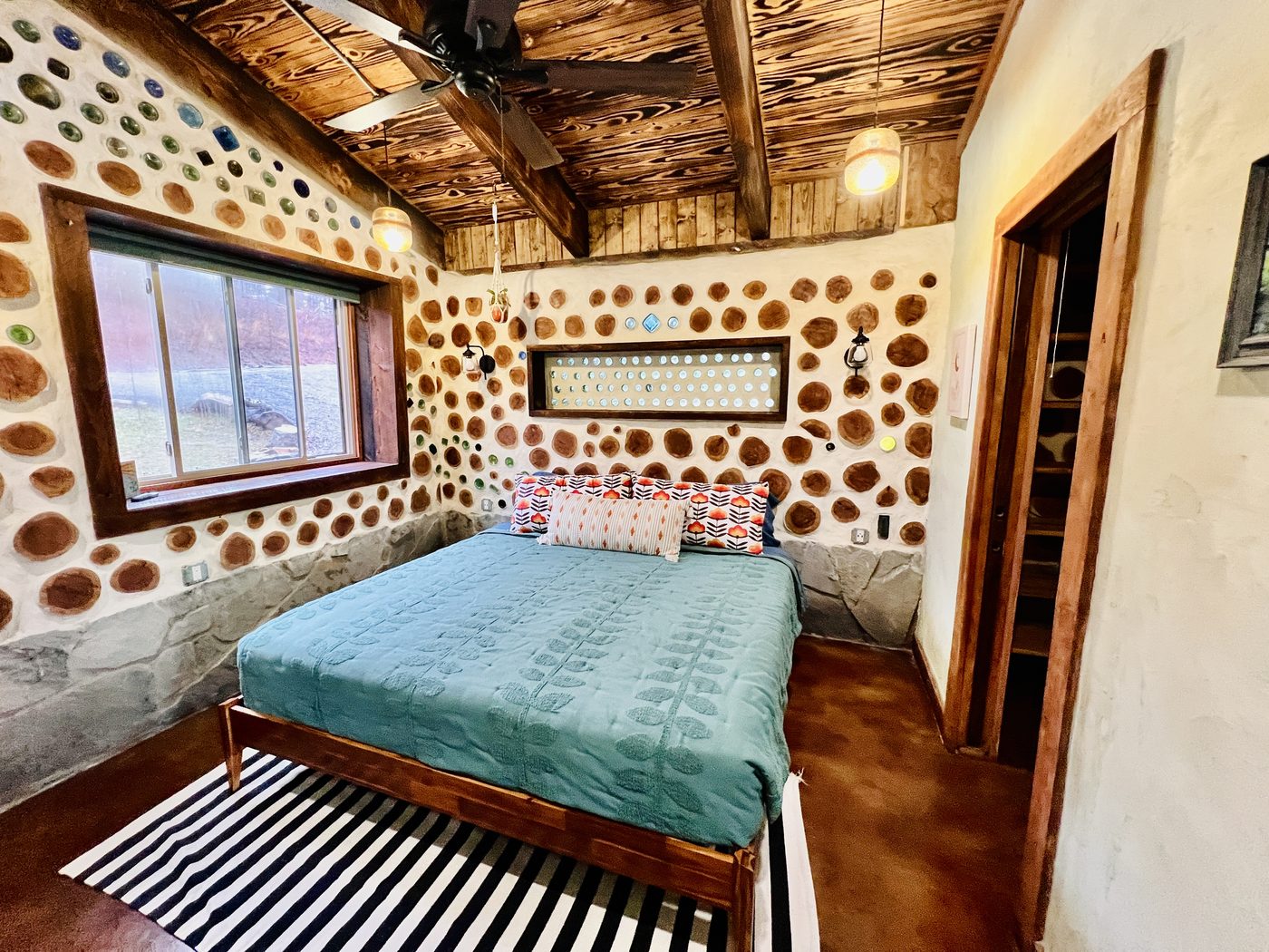 Goldfinch bedroom with cordwood walls and wood ceiling