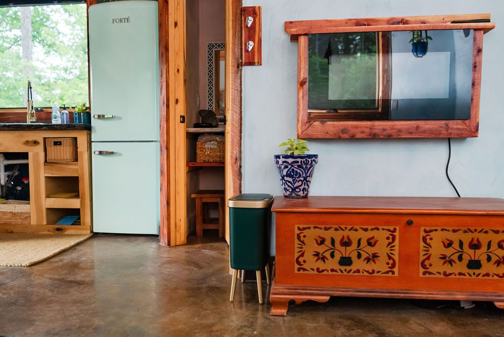 Whippoorwill living space with retro fridge, framed mirror and painted chest