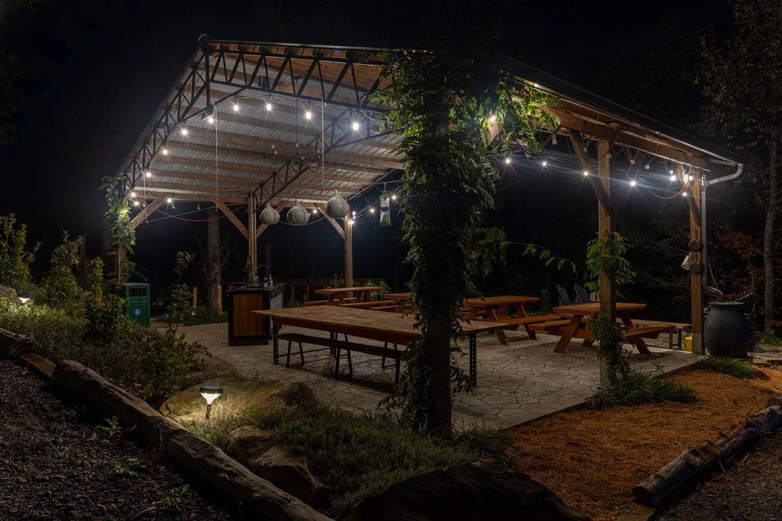 The event pavilion glowing with string lights at night