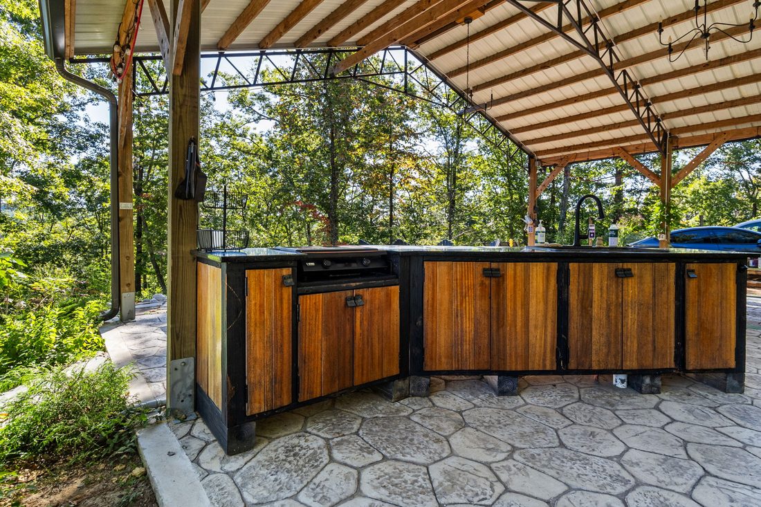 The outdoor kitchen counter and cabinets under the pavilion
