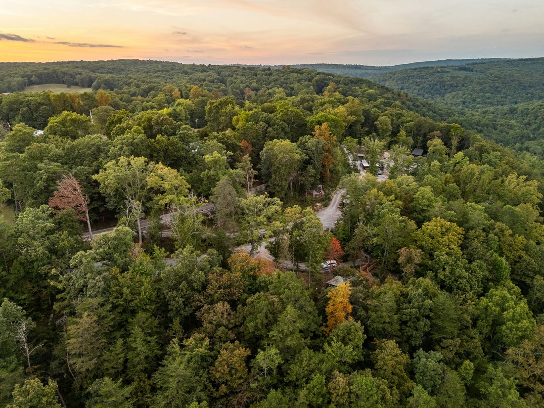 The retreat tucked into the ridge, seen from above at sunset